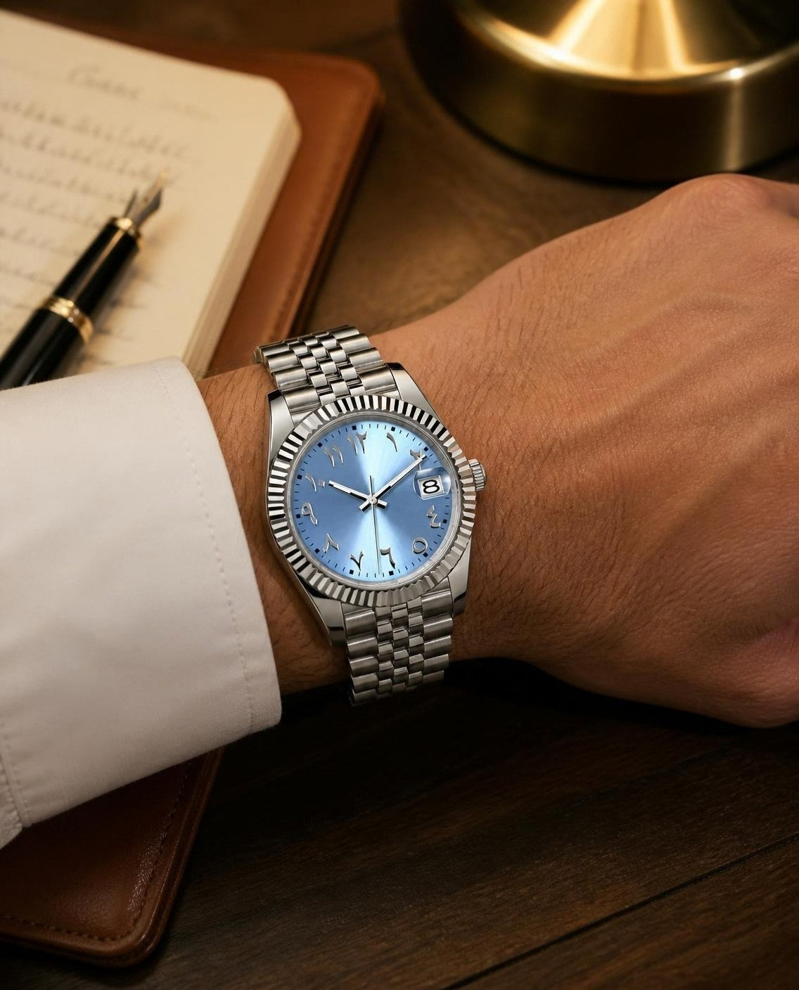 Crownline Date Arabic Ice Blue on the wrist at a writing desk