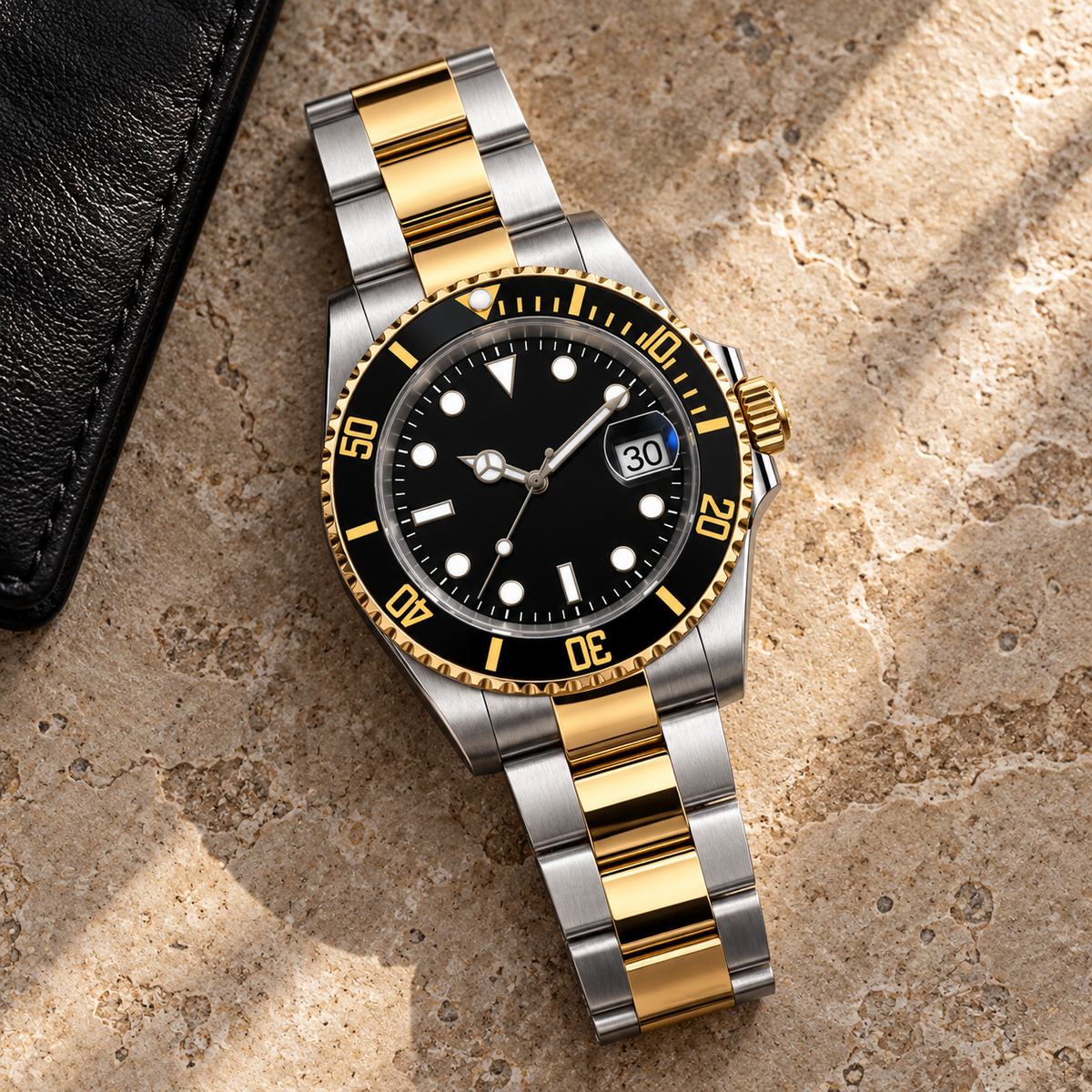 Marine Diver Imperial Gold two-tone watch with three-link bracelet laid on taupe limestone