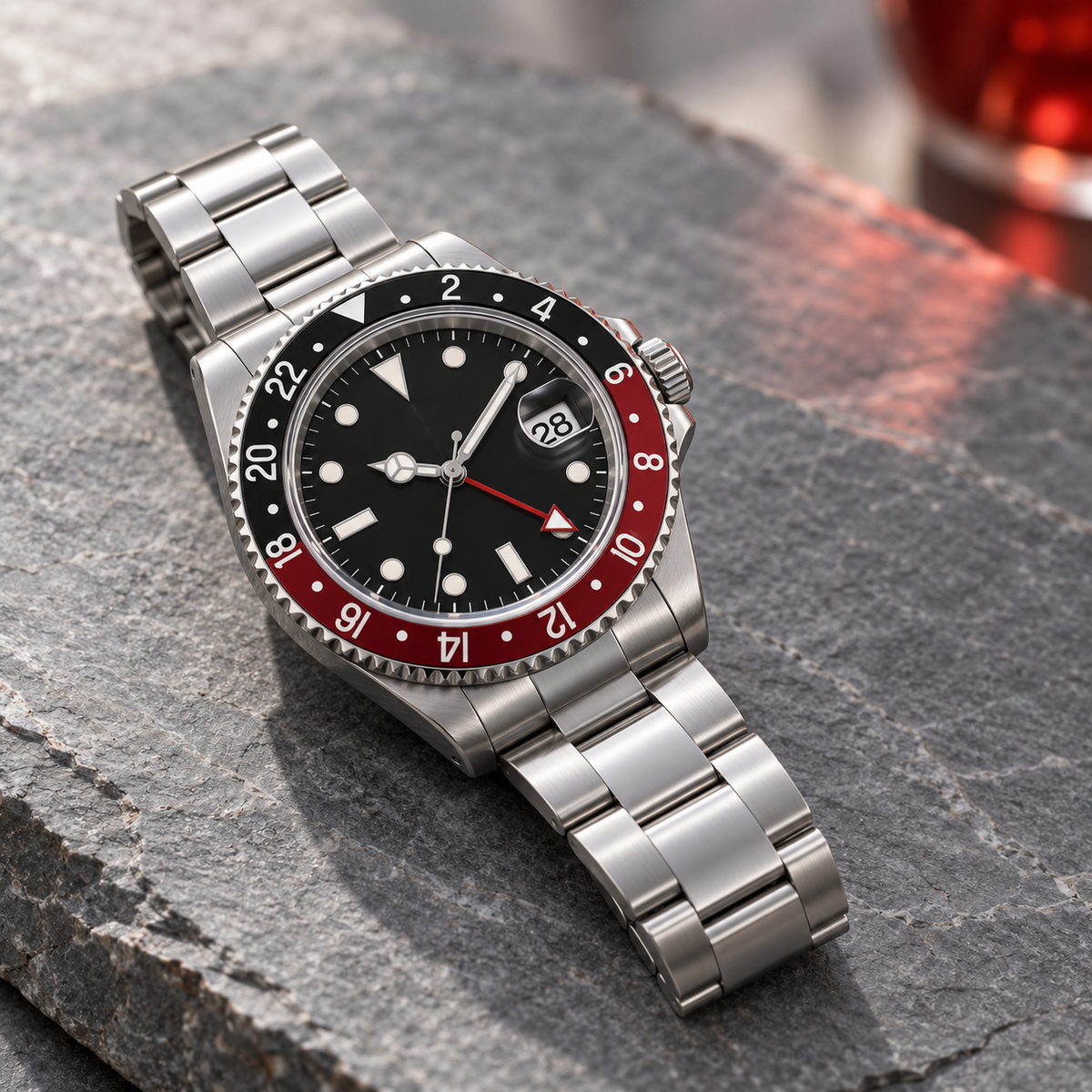 GMT Navigator Red and Black with Three-Link steel bracelet laid on gray slate
