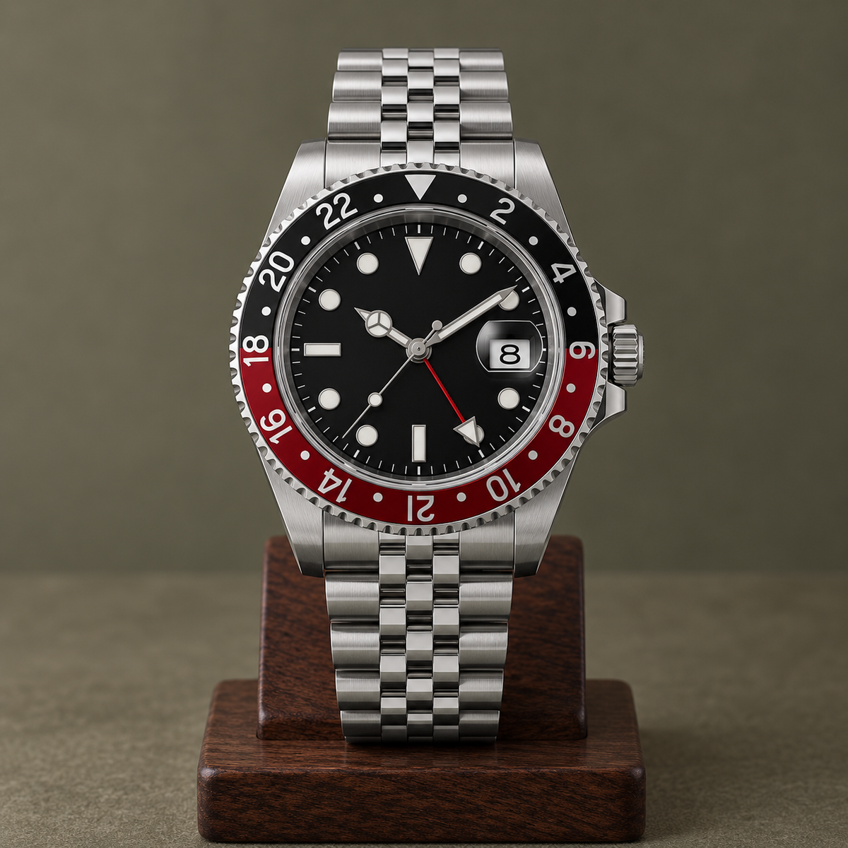 GMT Navigator Red and Black full watch with Jubilee bracelet on walnut stand, date showing 8