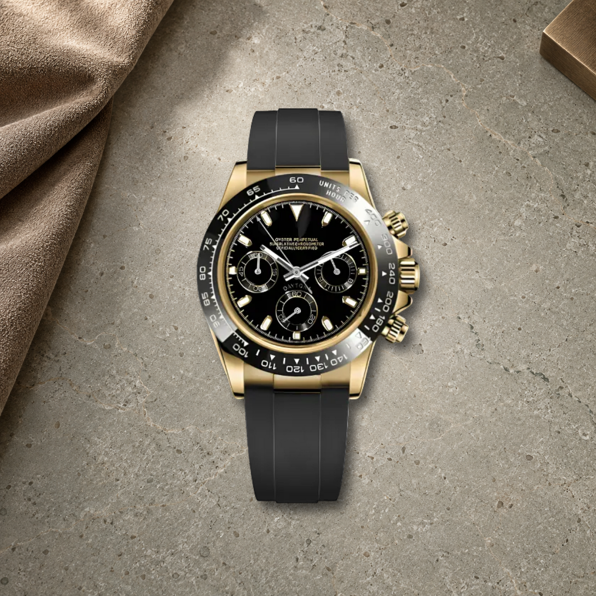 Gold & Black VK63 chronograph on warm grey-green stone and taupe suede