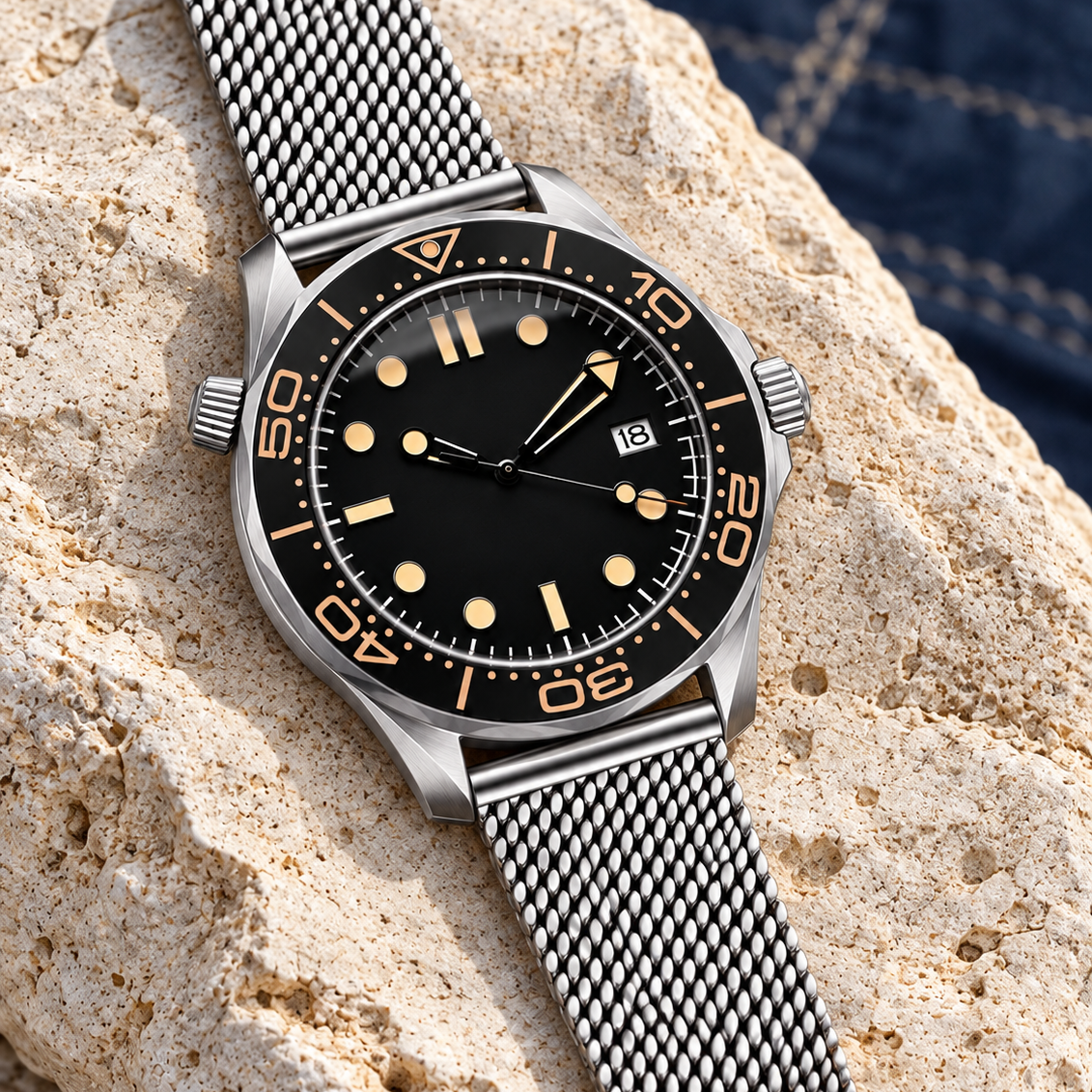 Oceanline Diver Abyss Black laid diagonally on pale dune stone with its mesh bracelet visible