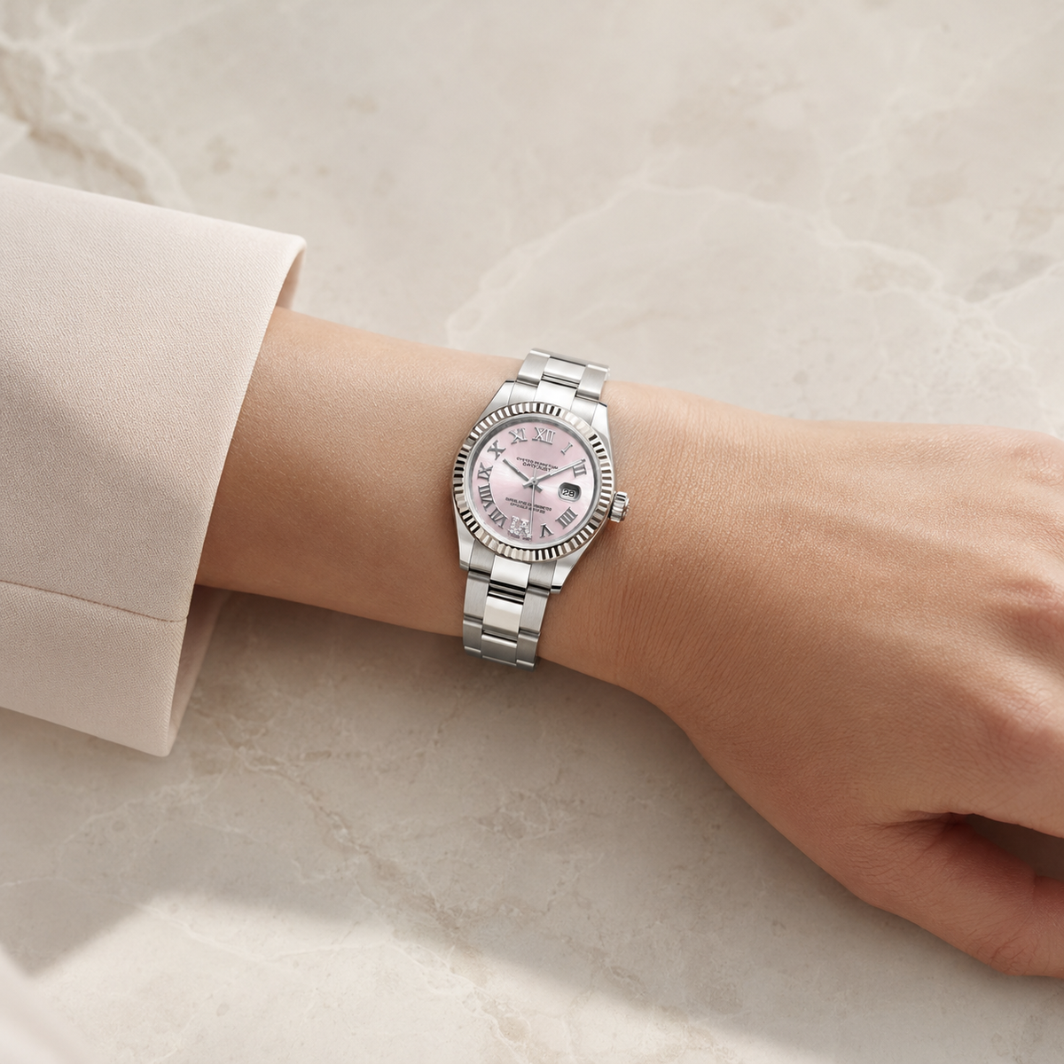 A silver-tone stainless steel watch with a pink dial and a matching pink mother-of-pearl bracelet, shown worn on a person's wrist against a light beige marble background.