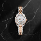 women's Day-Date watch with a two-tone stainless steel and rose gold Oyster bracelet, a white mother-of-pearl dial with Roman numerals, and a bezel set with clear crystals.