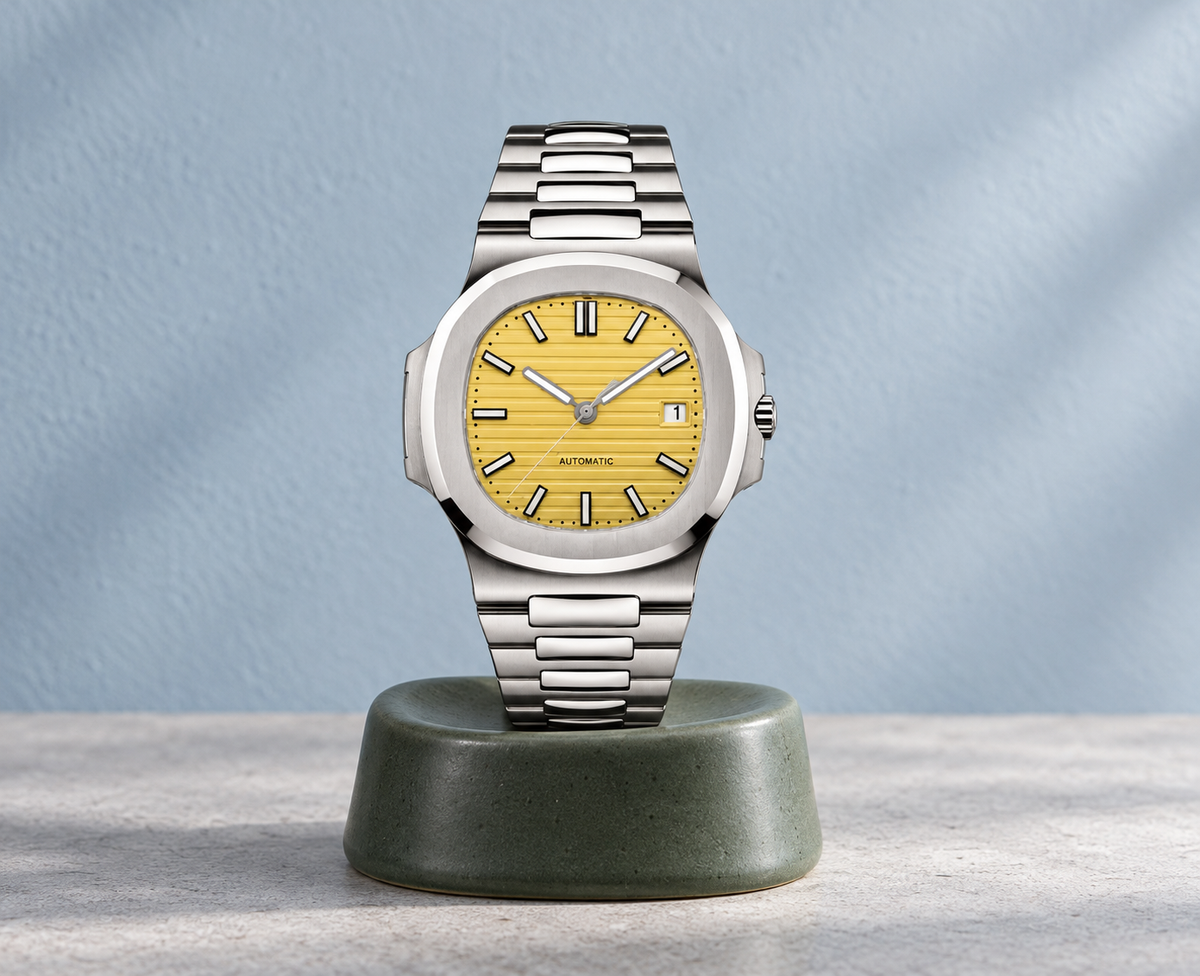 Nautiko Sahara yellow-dial watch on a sage ceramic support against cool pale plaster