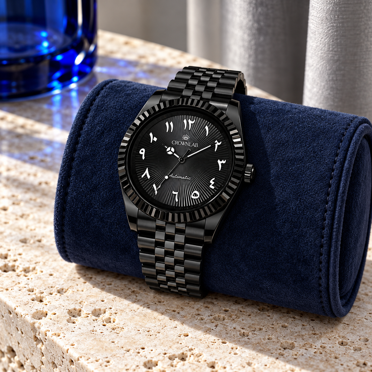 Black sunray Arabic dial watch on a taupe cushion with sage wool and walnut