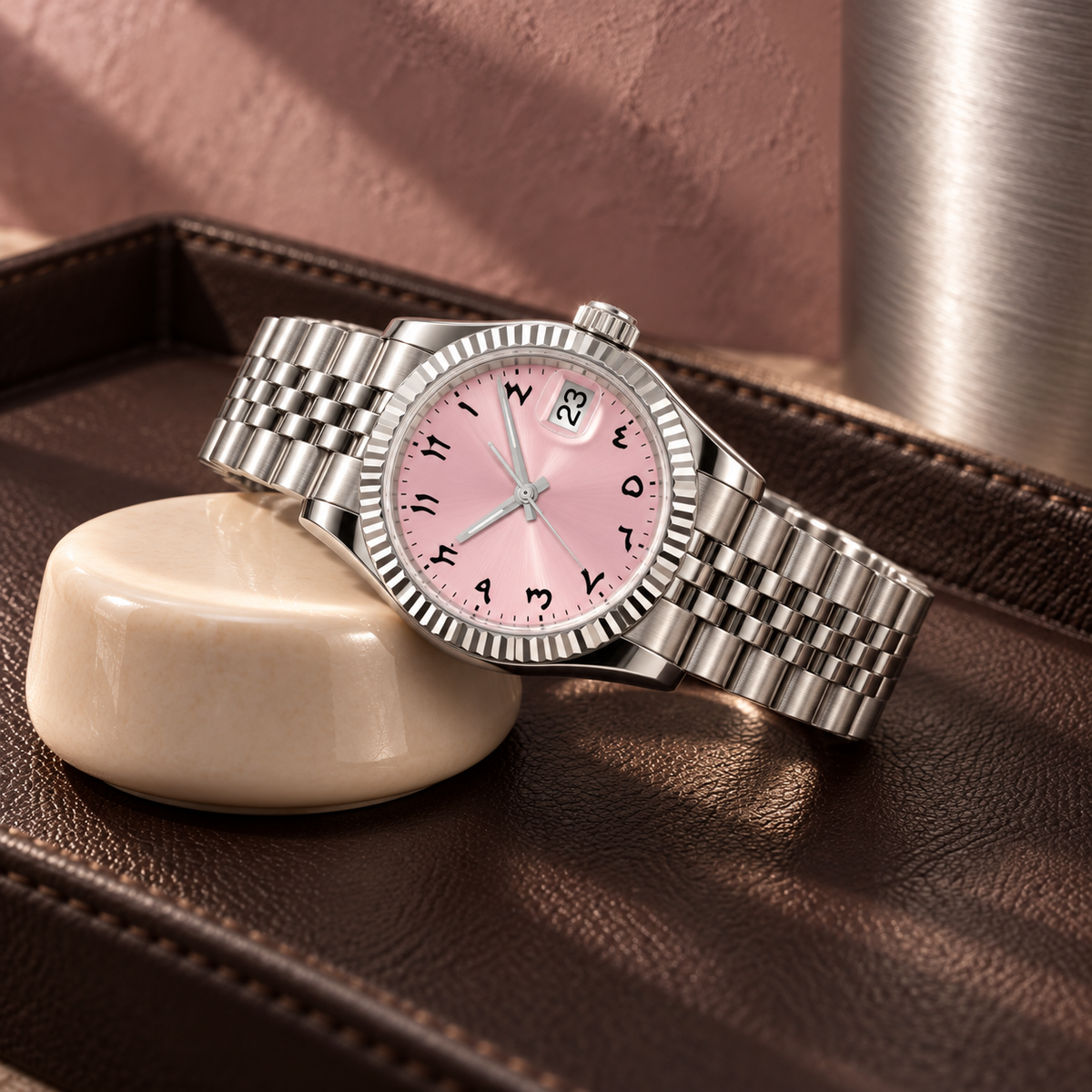 Pink Arabic numeral watch across ivory ceramic support on dark brown leather valet