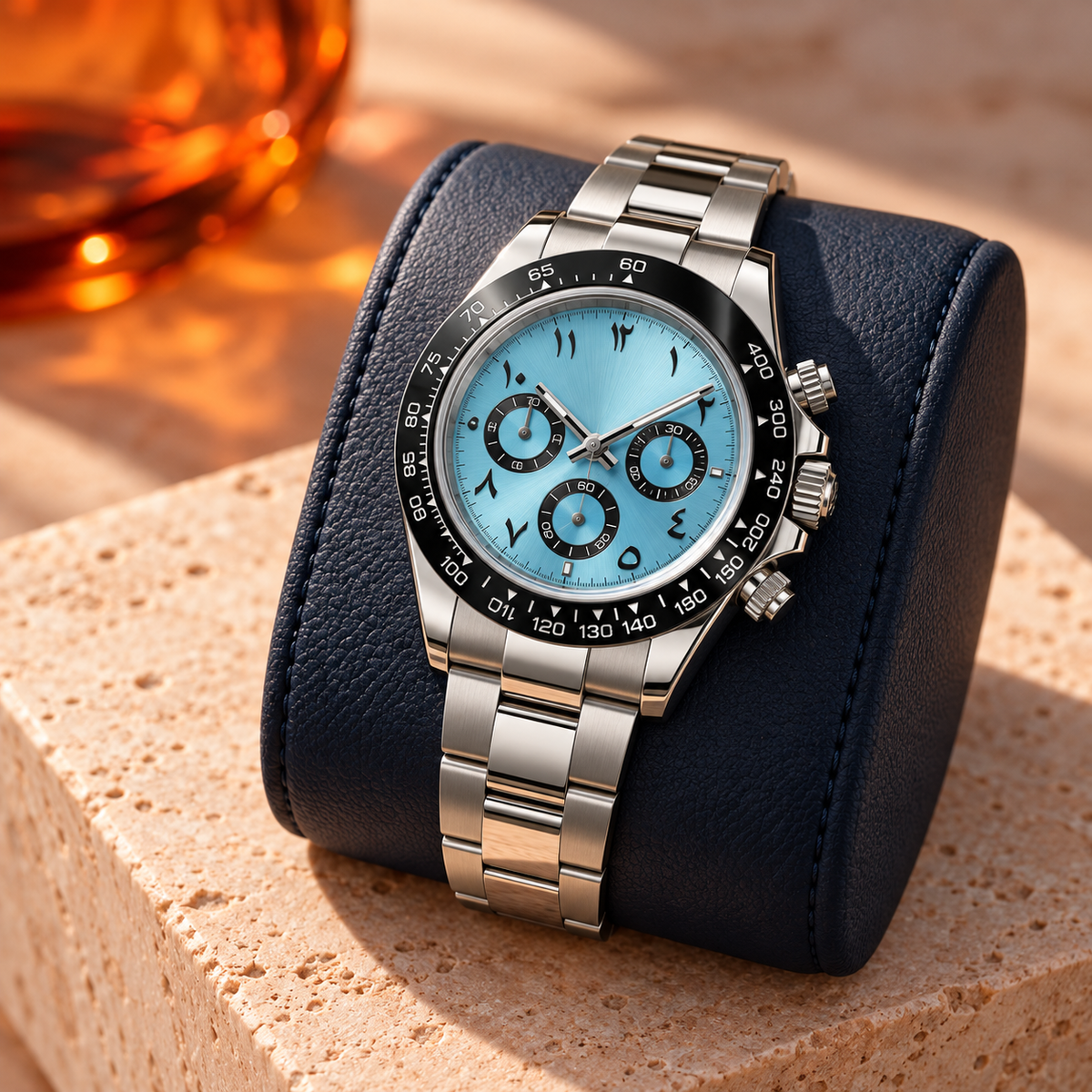 Ice blue chronograph resting in an olive suede tray over walnut