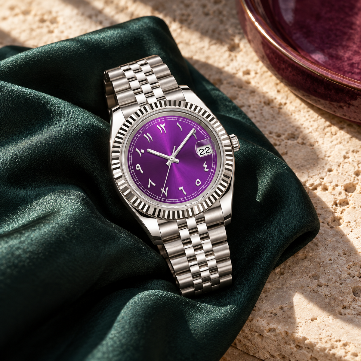 Purple dial watch resting on blush velvet cushion over charcoal slate