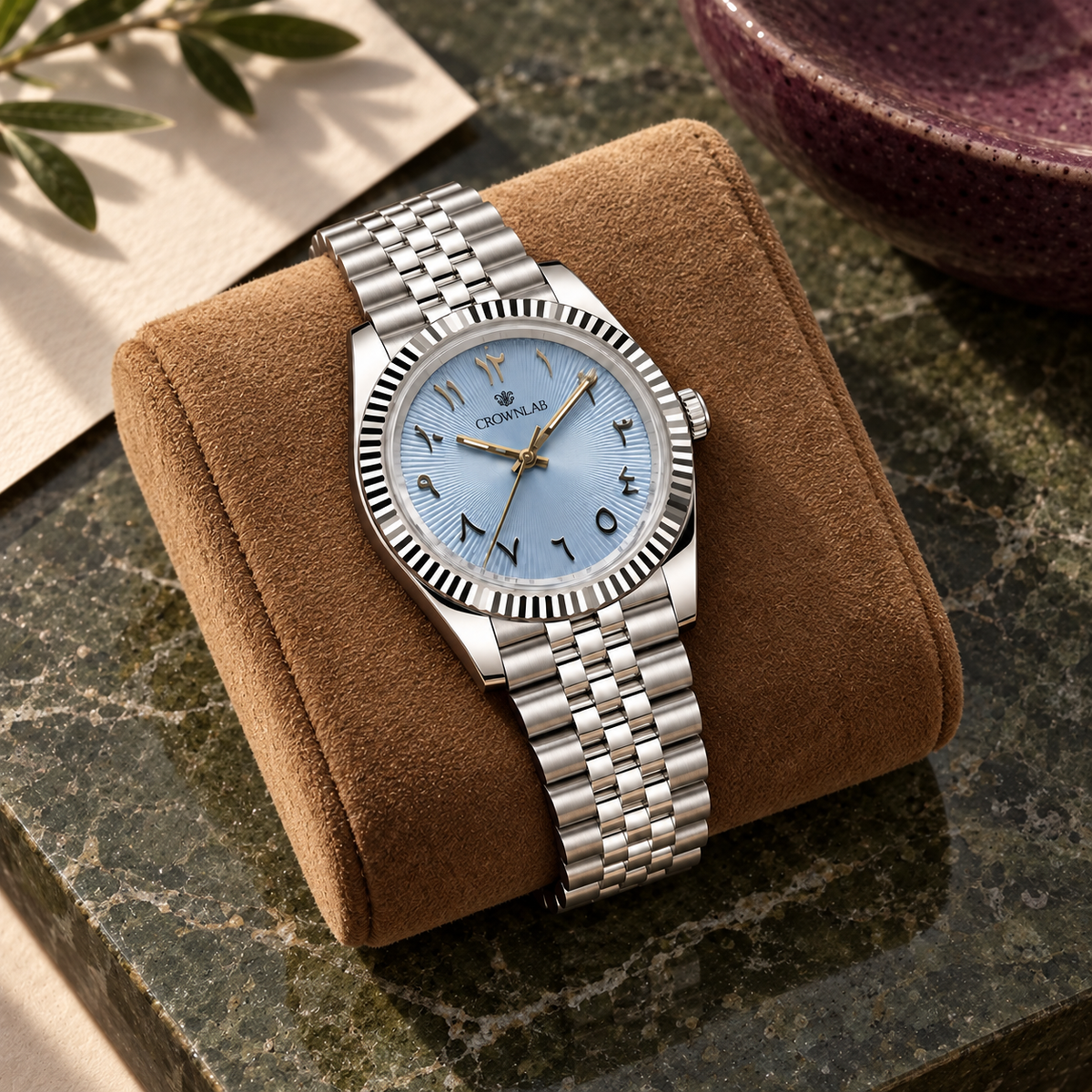 Arabic Heritage ice-blue sunray watch on tan suede against olive stone