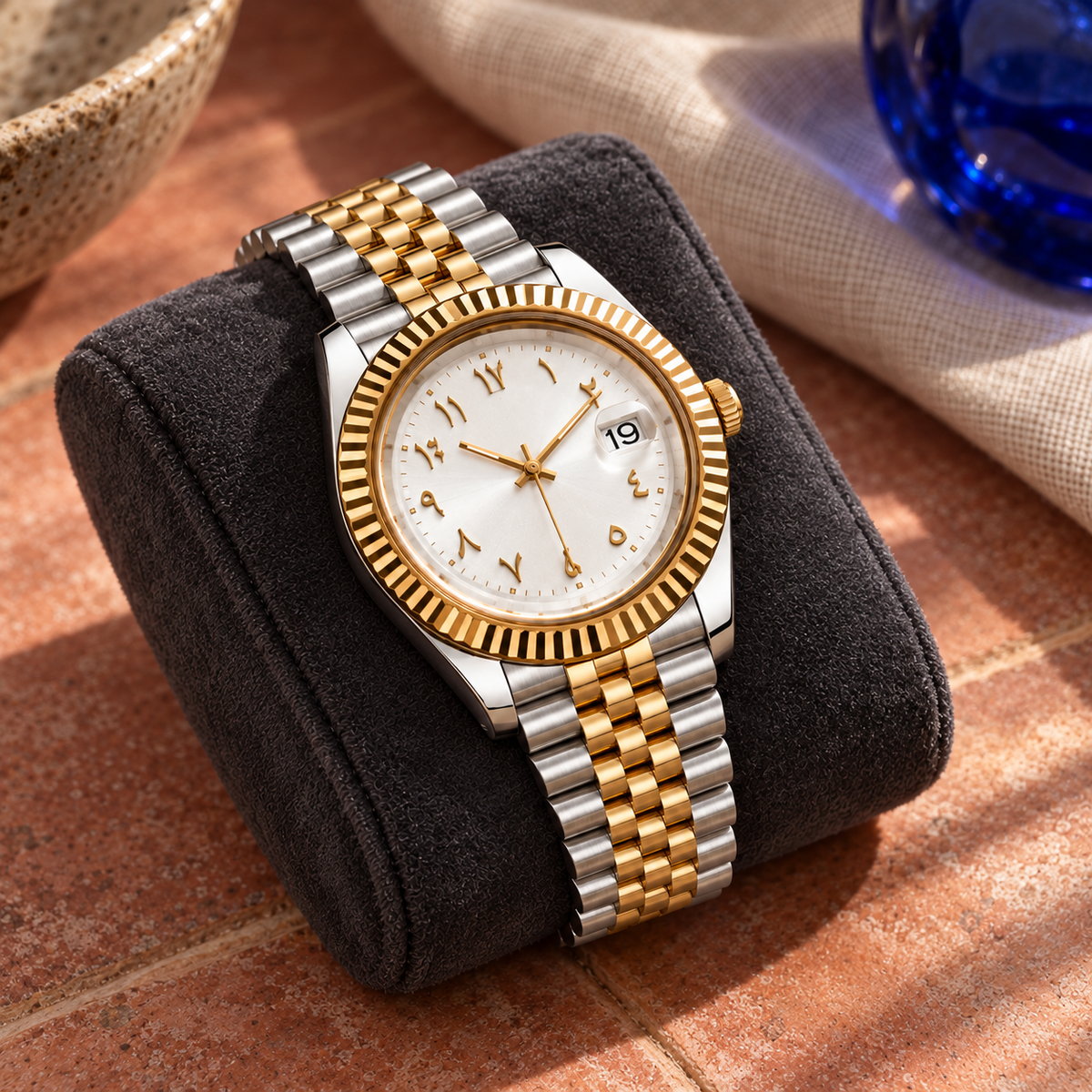 Arabic Heritage frost-white two-tone watch on charcoal cushion and rose-clay tile