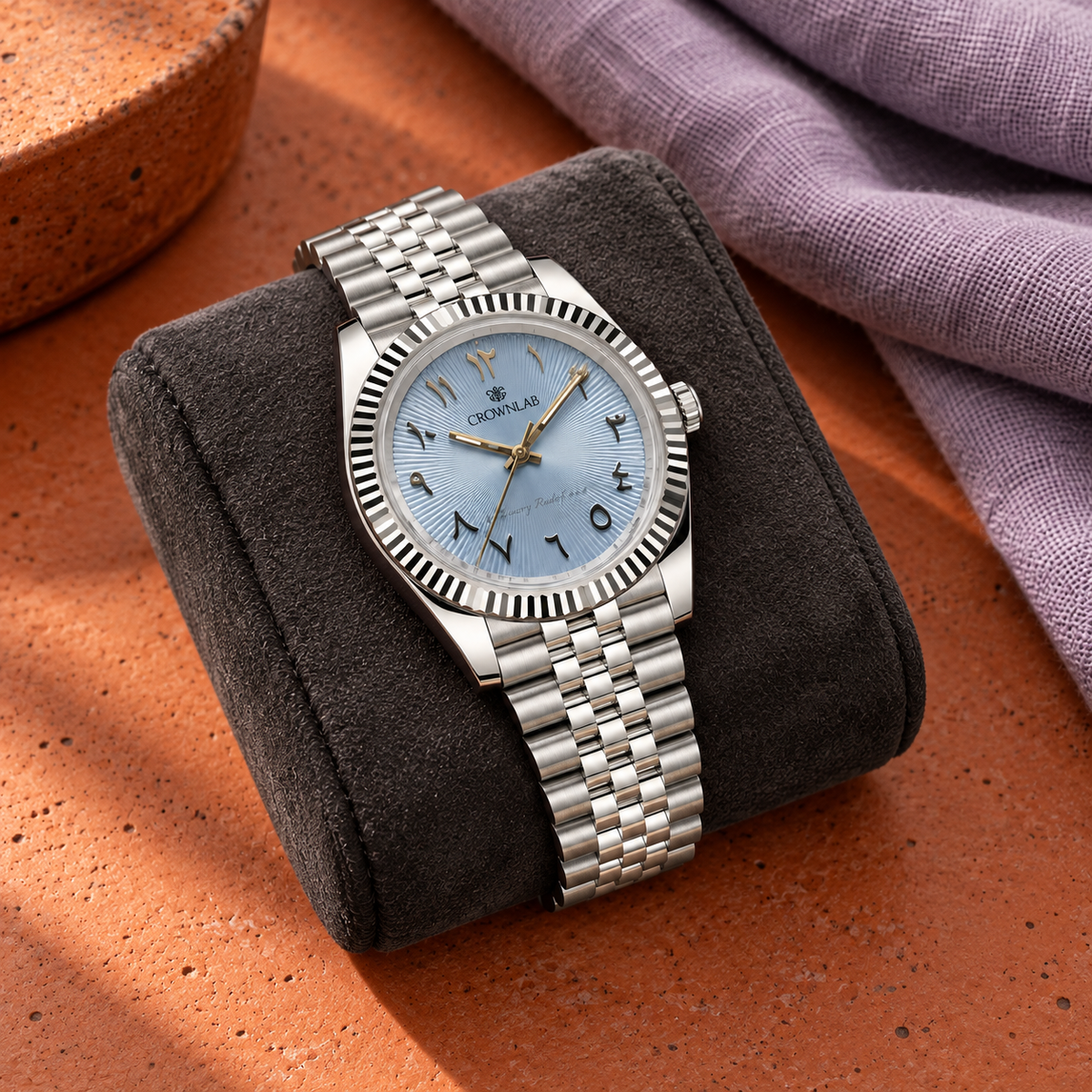 Arabic Heritage ice-blue sunray watch on charcoal suede over burnt-orange ceramic