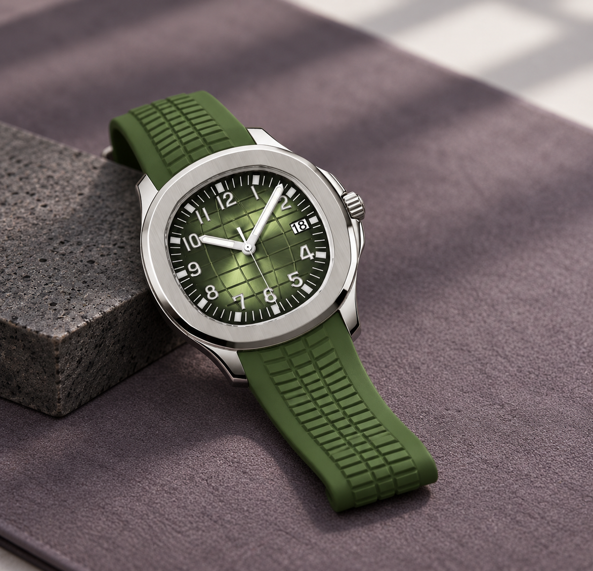 Nautiko Olive Green watch laid diagonally on a plum-gray mat and basalt
