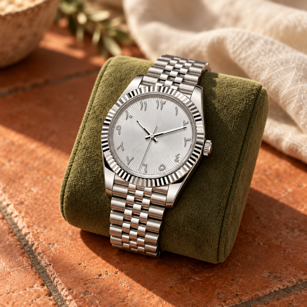 Arabic Heritage silver sunray watch on moss suede above terracotta