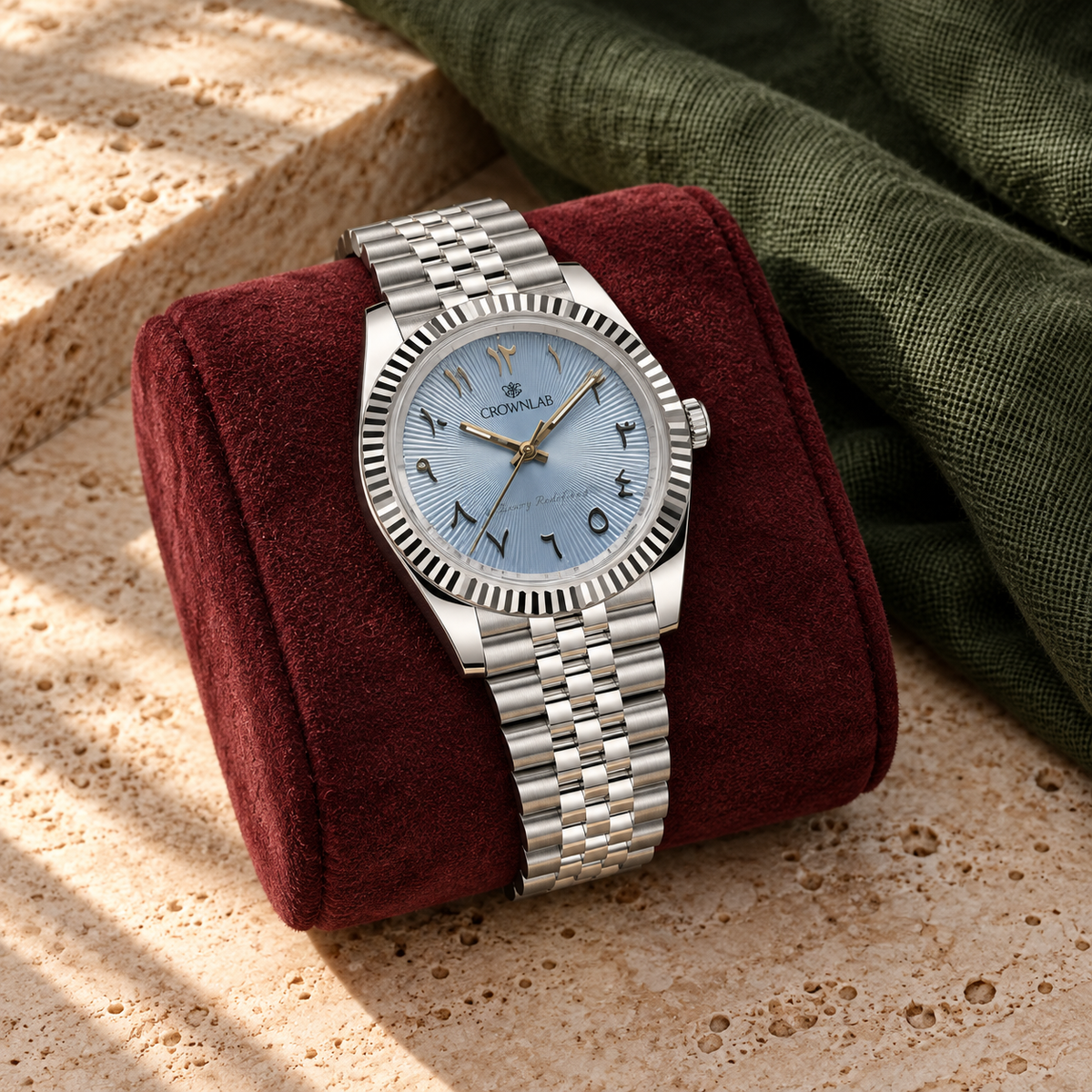 Arabic Heritage ice-blue sunray watch on burgundy suede above warm travertine