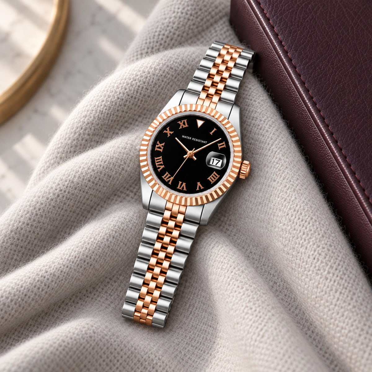 Lady Crownline Two-Tone Rose Gold Black Roman watch laid on pale cashmere