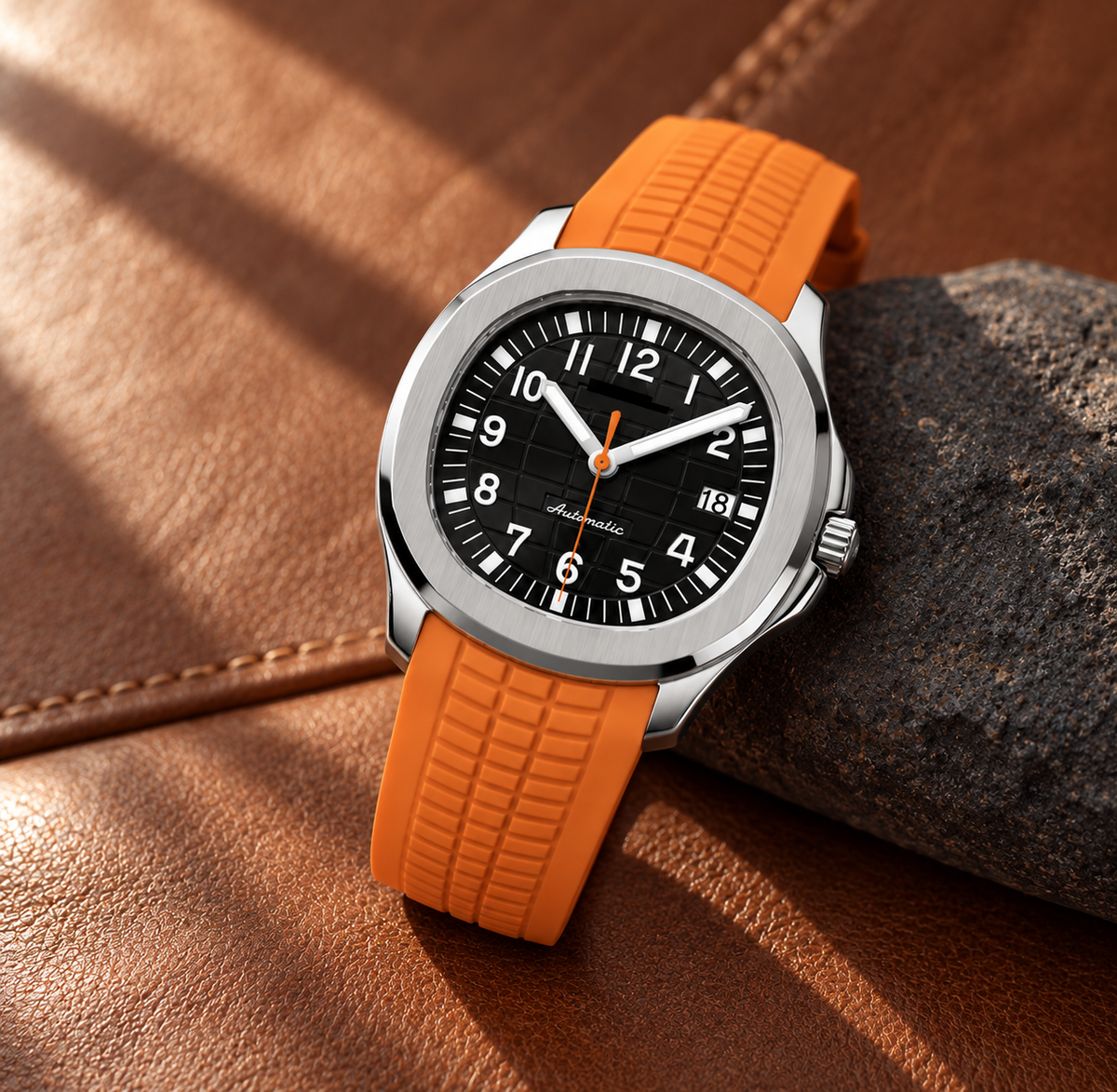 Nautiko Black & Orange watch laid on clay-brown leather and charcoal stone