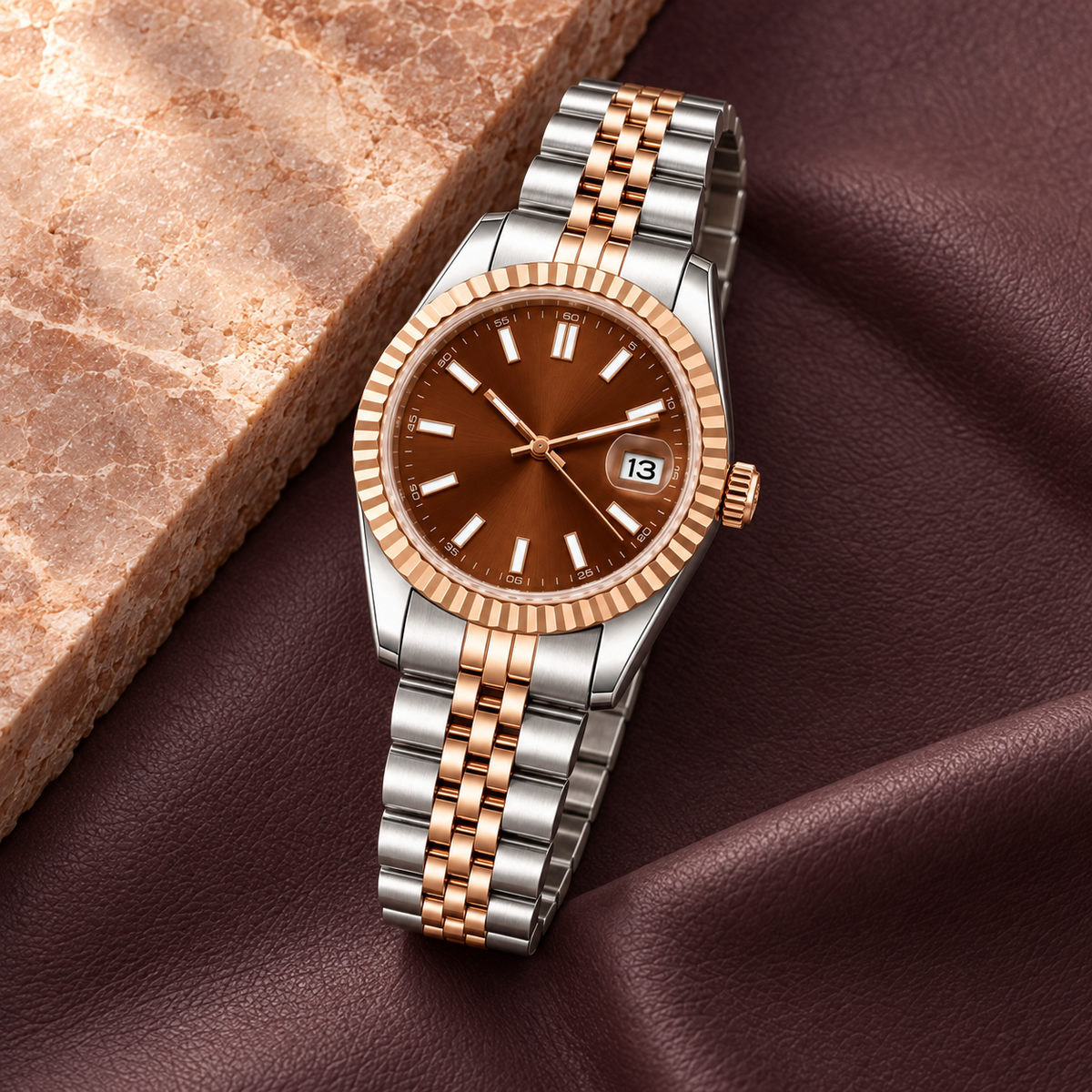 Rose Chocolate Baton watch showing its crown and two-tone Jubilee bracelet on plum leather
