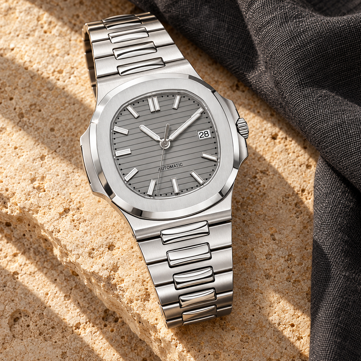 Nautiko Sports Grey integrated steel watch on warm limestone and charcoal linen