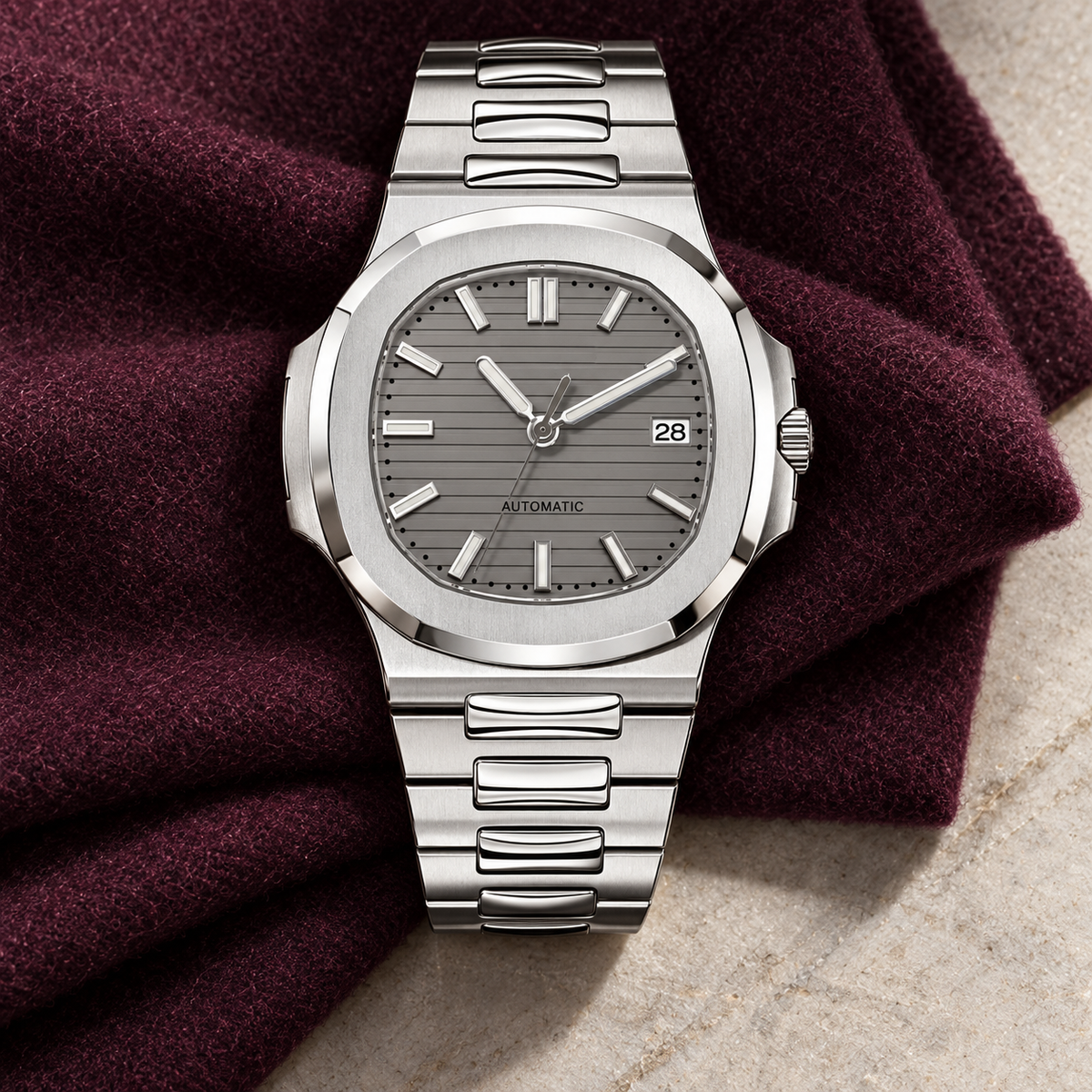 Nautiko Sports Grey watch laid on plum wool over pale stone