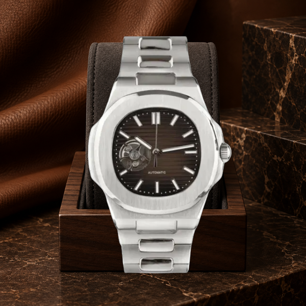 Open Heart Nautiko Chocolate integrated bracelet watch on a dark suede walnut display against brown stone