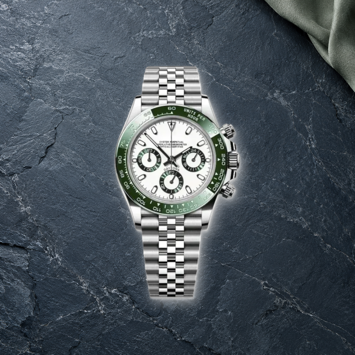 Speedline Alpine Green Racer chronograph lying face-up on blue-gray slate and sage suede